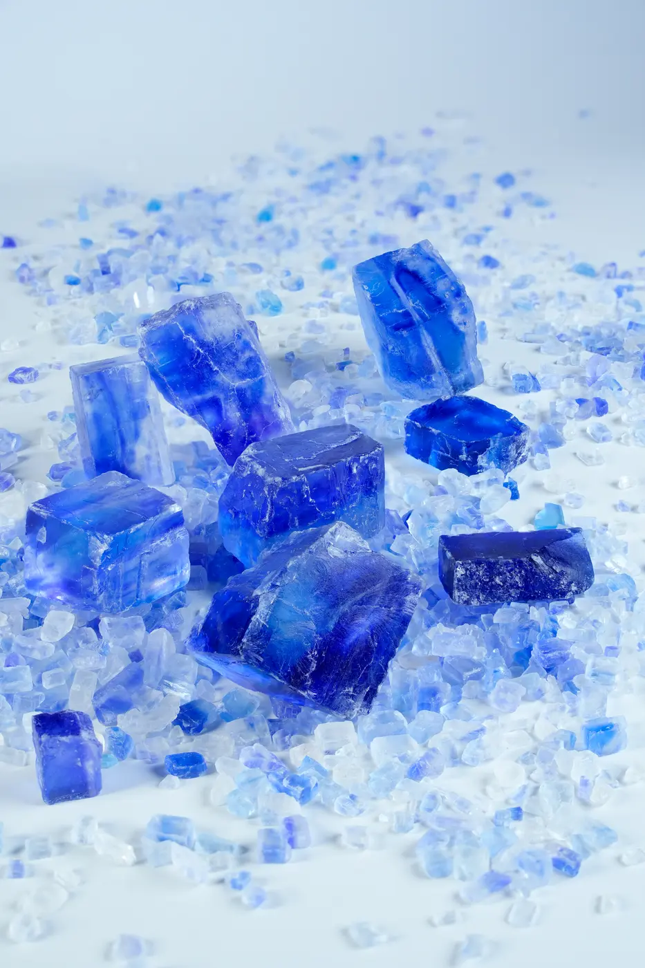 Persian blue mineral salt crystals arranged on a pale surface